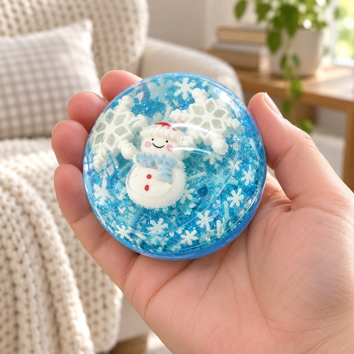Christmas Coconut Oil Squishy Ball in Gift Box, 6.5 cm (Snowman, blue), held in a hand to show the real size