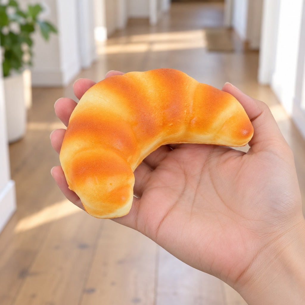 Croissant Squishy, Realistic Slow Rising Bread (12.5 cm), held in a hand to show the real size