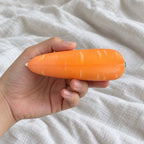 Crunchy Carrot Squishy, Crispy PU Vegetable, held toward the camera, first-person view