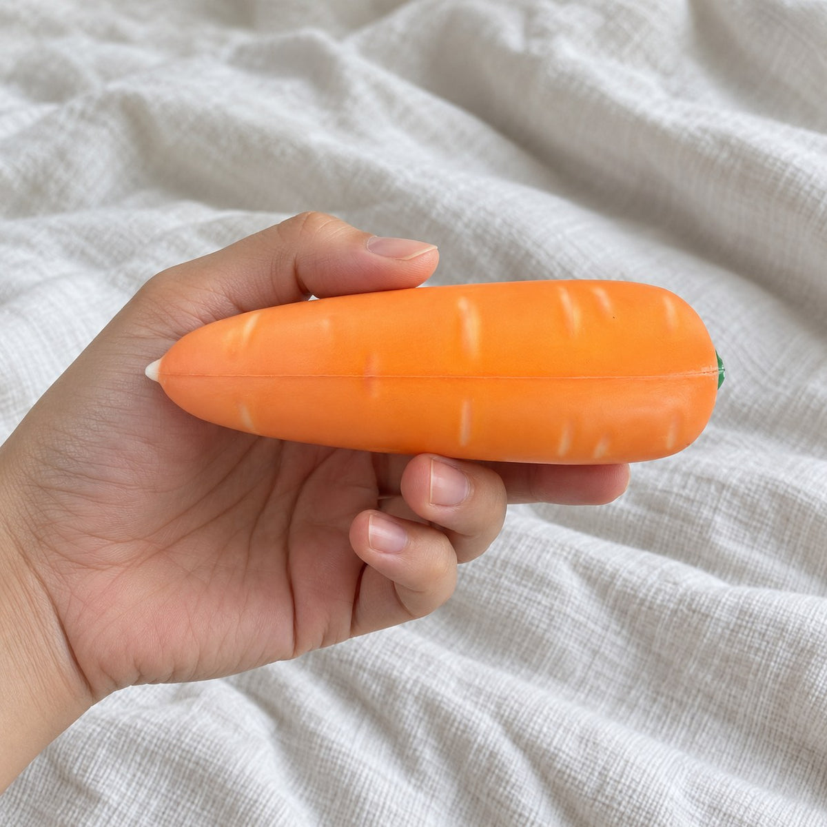 Crunchy Carrot Squishy, Crispy PU Vegetable, held toward the camera, first-person view