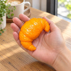 Crunchy Croissant Squishy, Handmade, held in a hand to show the real size