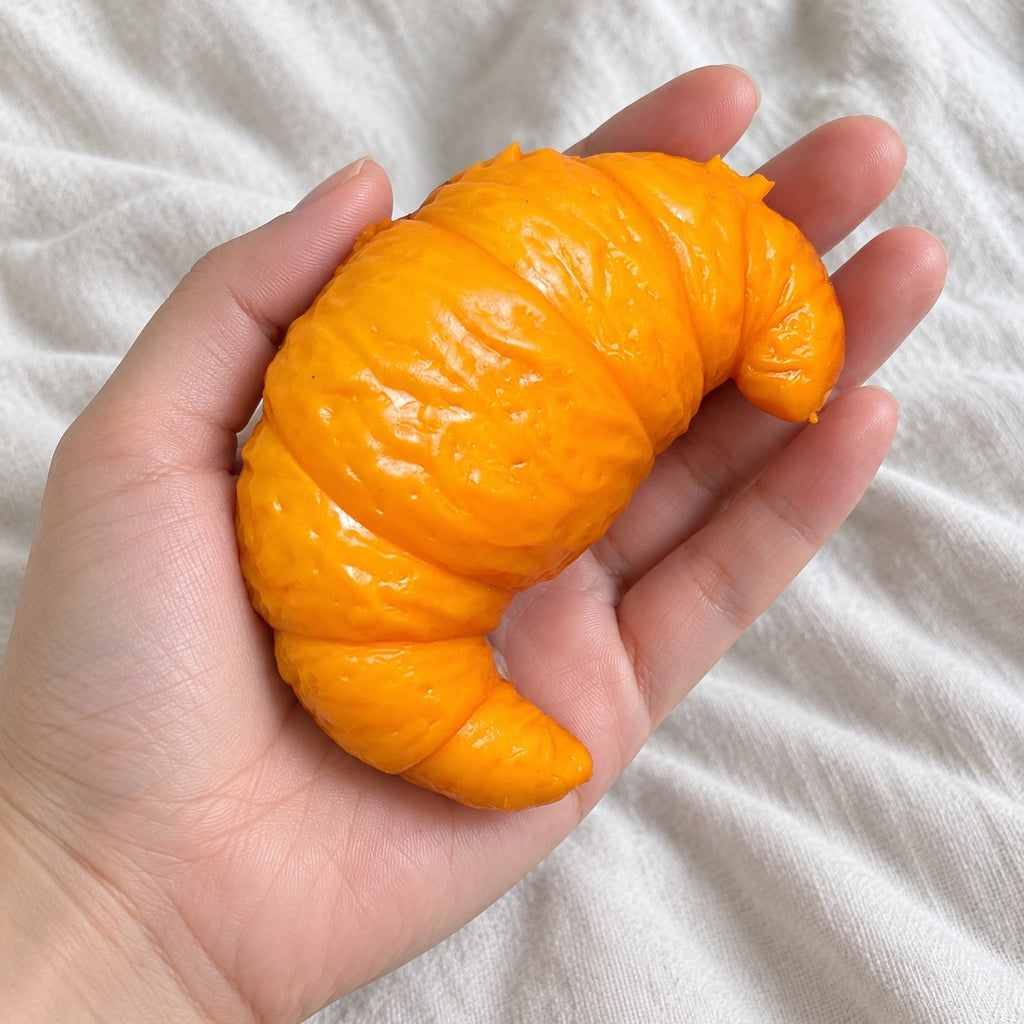 Croissant squishy crunchy, held toward the camera, first-person view