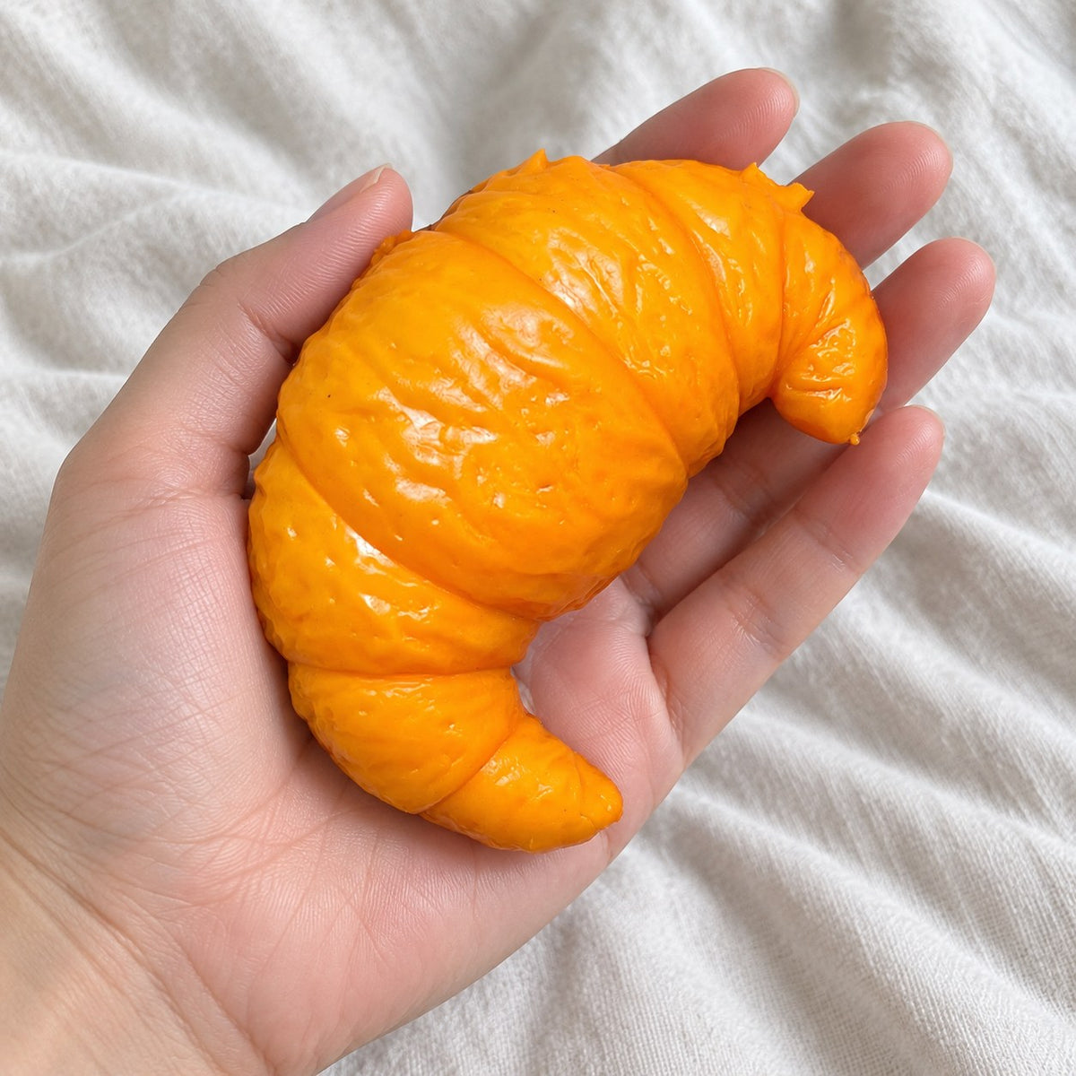 Croissant squishy crunchy, held toward the camera, first-person view
