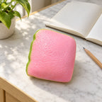 Guava squishy, on a desk with a notebook and pencil