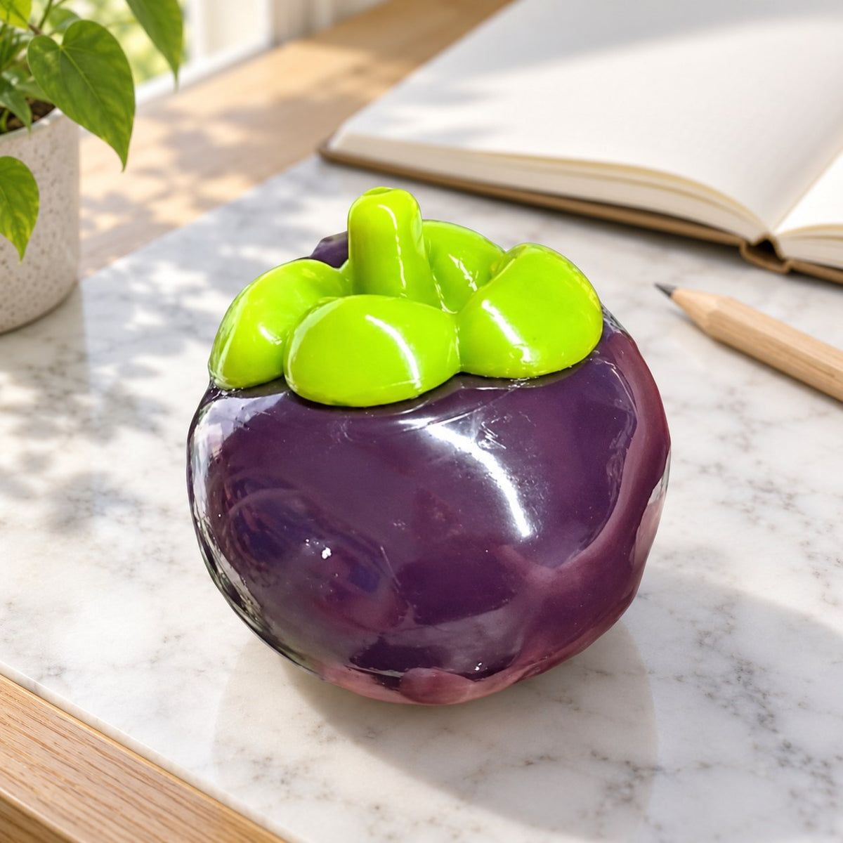 Mangosteen squishy crunchy, on a desk with a notebook and pencil