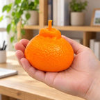 Orange squishy, held in a hand to show the real size