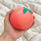 Peach squishy crunchy, held toward the camera, first-person view