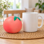 Crunchy Peach Squishy, Handmade, next to a coffee mug for size comparison
