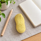 Peanut squishy crunchy, on a desk with a notebook and pencil
