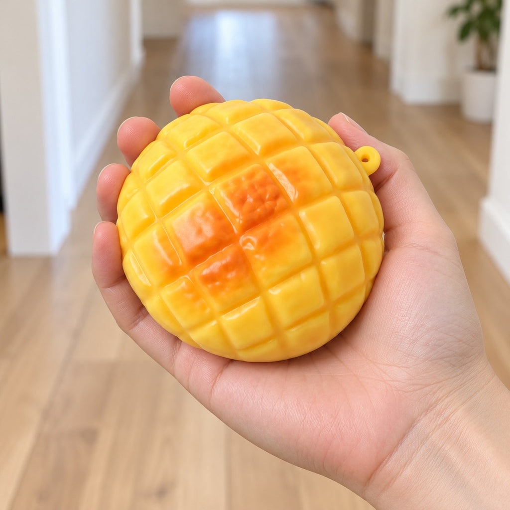 Pineapple bun squishy, held in a hand to show the real size