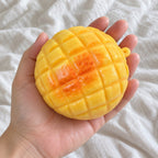 Pineapple bun squishy crunchy, held toward the camera, first-person view