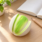 Pistachio squishy crunchy, on a desk with a notebook and pencil