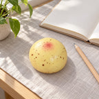 Potato squishy slow rising, on a desk with a notebook and pencil