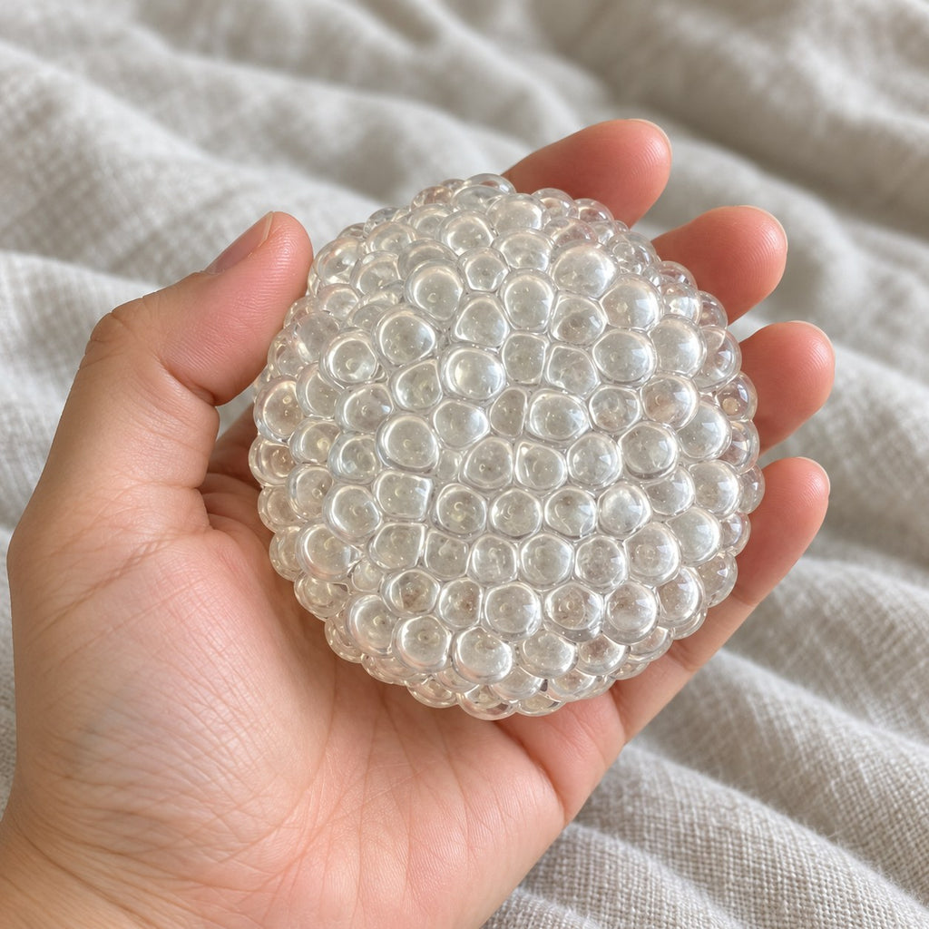 Glass bubble squishy (Clear), held toward the camera, first-person view