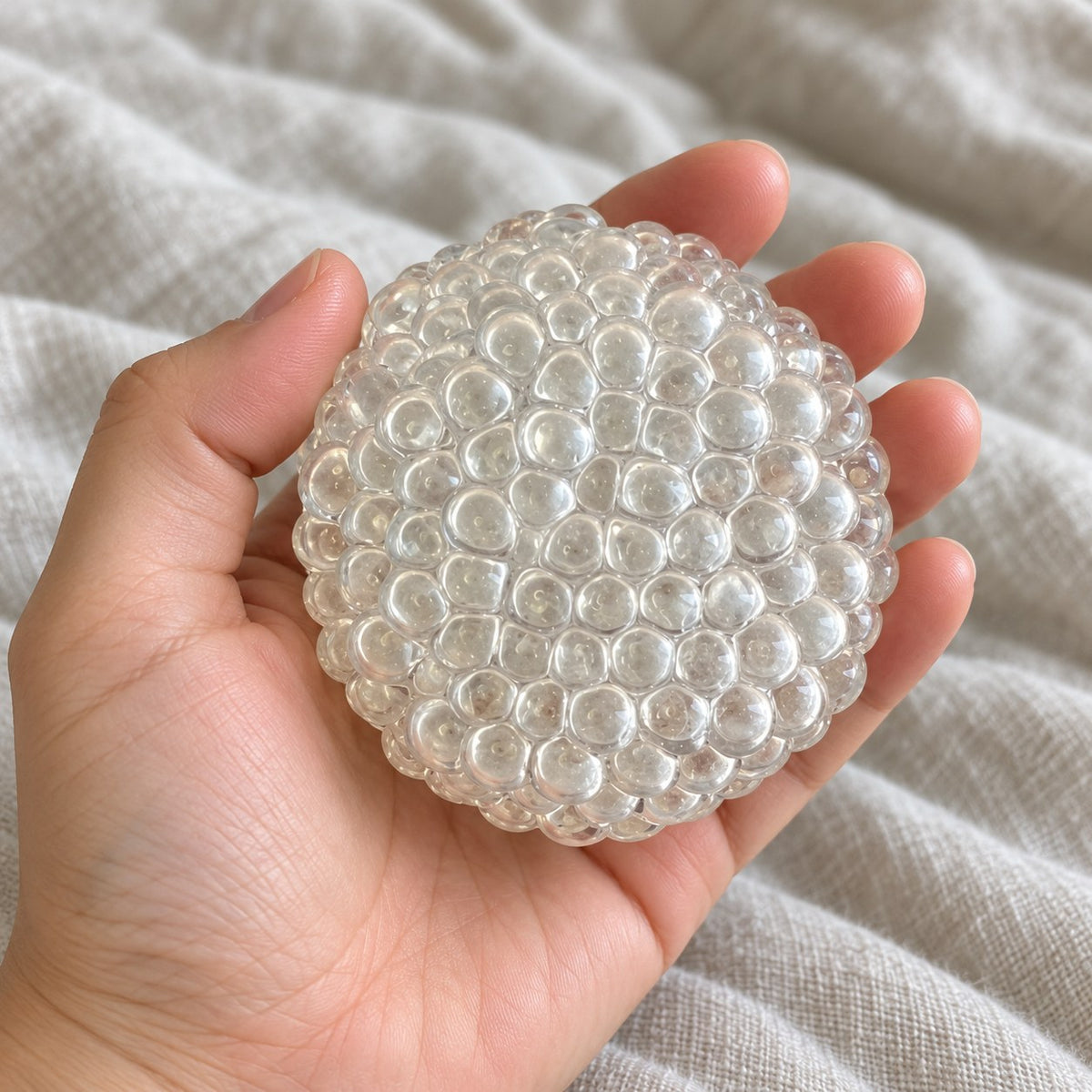 Glass bubble squishy (Clear), held toward the camera, first-person view