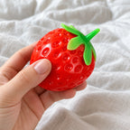 Strawberry squishy taba, held toward the camera, first-person view