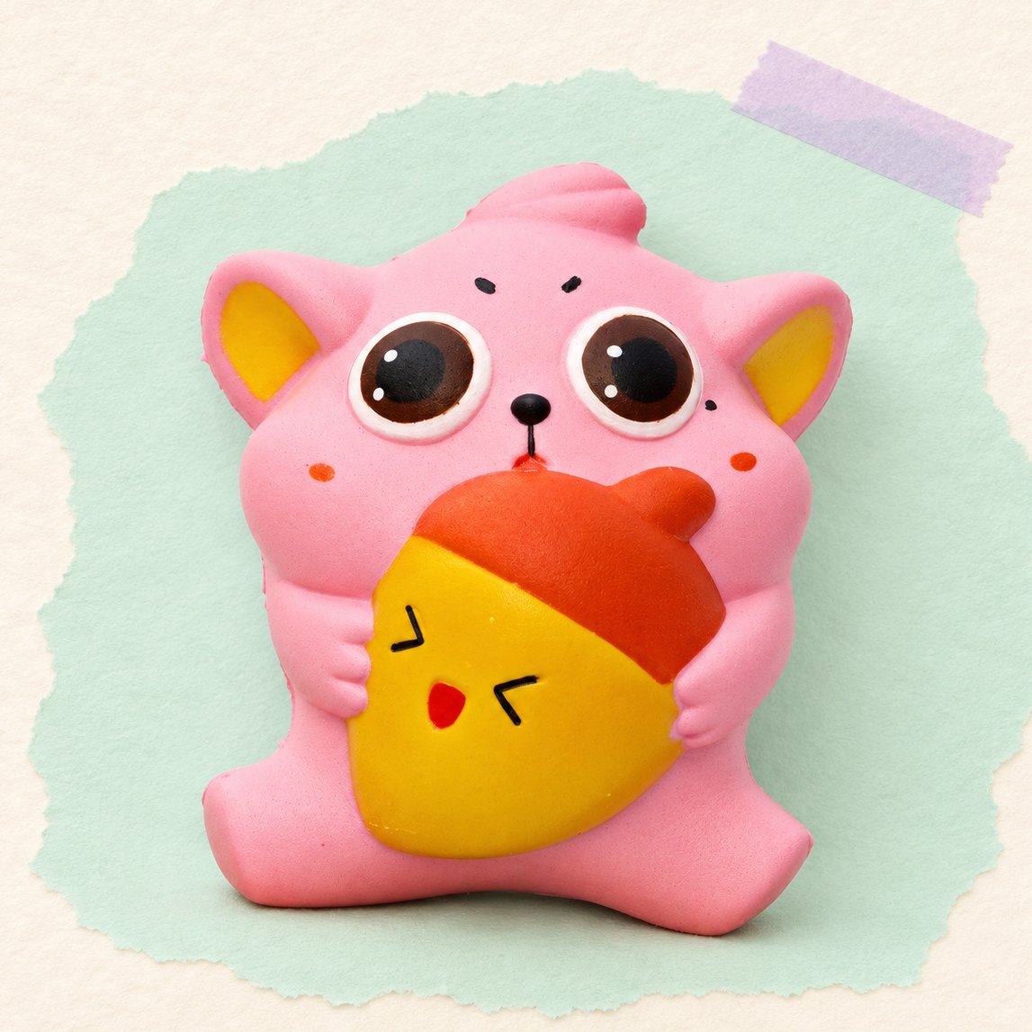 Dikke kat squishy met eikel op pastelkleurig papier
