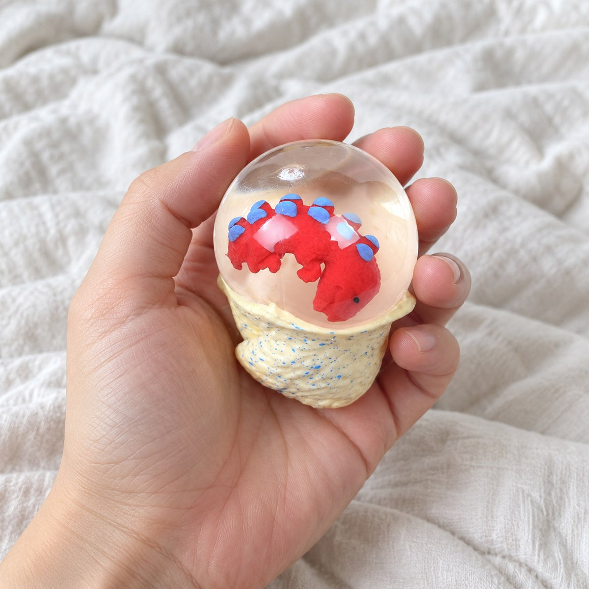 Dinosaur Egg Squishy, Water Ball with Baby Dino, held toward the camera, first-person view