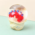Dinosaur egg squishy water ball with baby dino, product photo on pastel paper