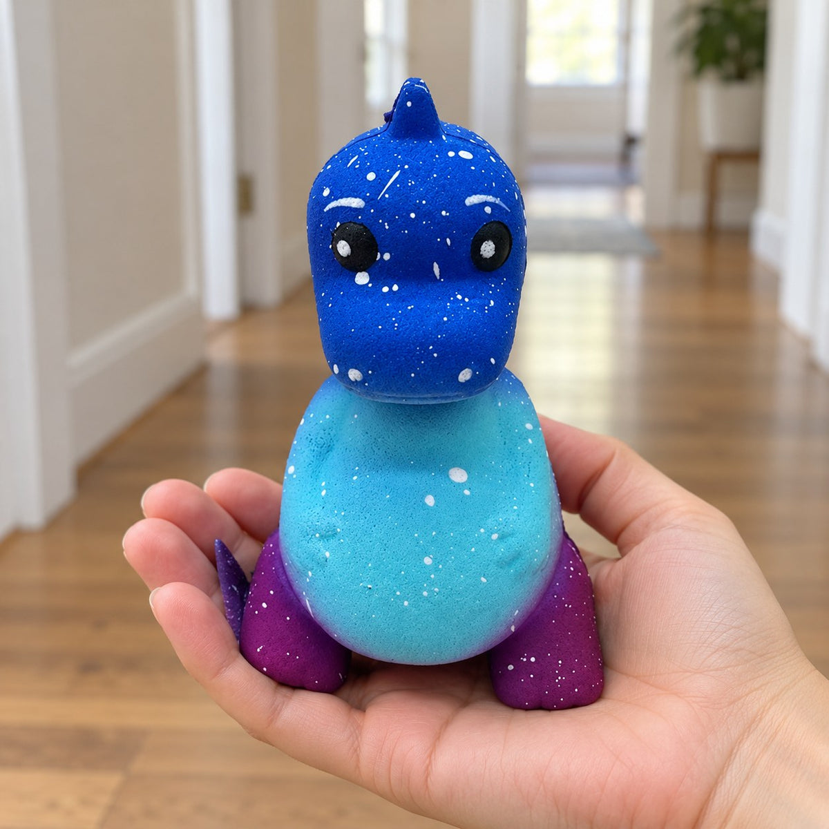 Dinosaurus squishy, galaxy slow rising, 10,5 cm (Blauwe galaxy), in de hand om de echte grootte te laten zien