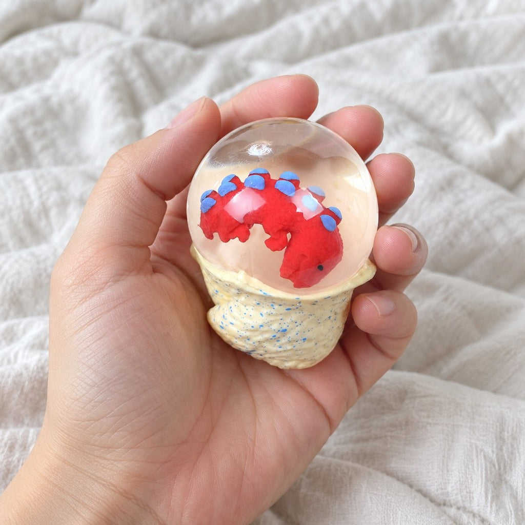 Set fra egne øjne: dinosauræg squishy med vand holdt frem mod kameraet