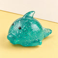 Dolphin squishy mochi – Big Mochi Squishy Dolphin with Glitter, product photo on pastel paper