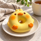 Squishy dónut cerdito o pato, pan flotador, en un plato sobre la mesa del desayuno