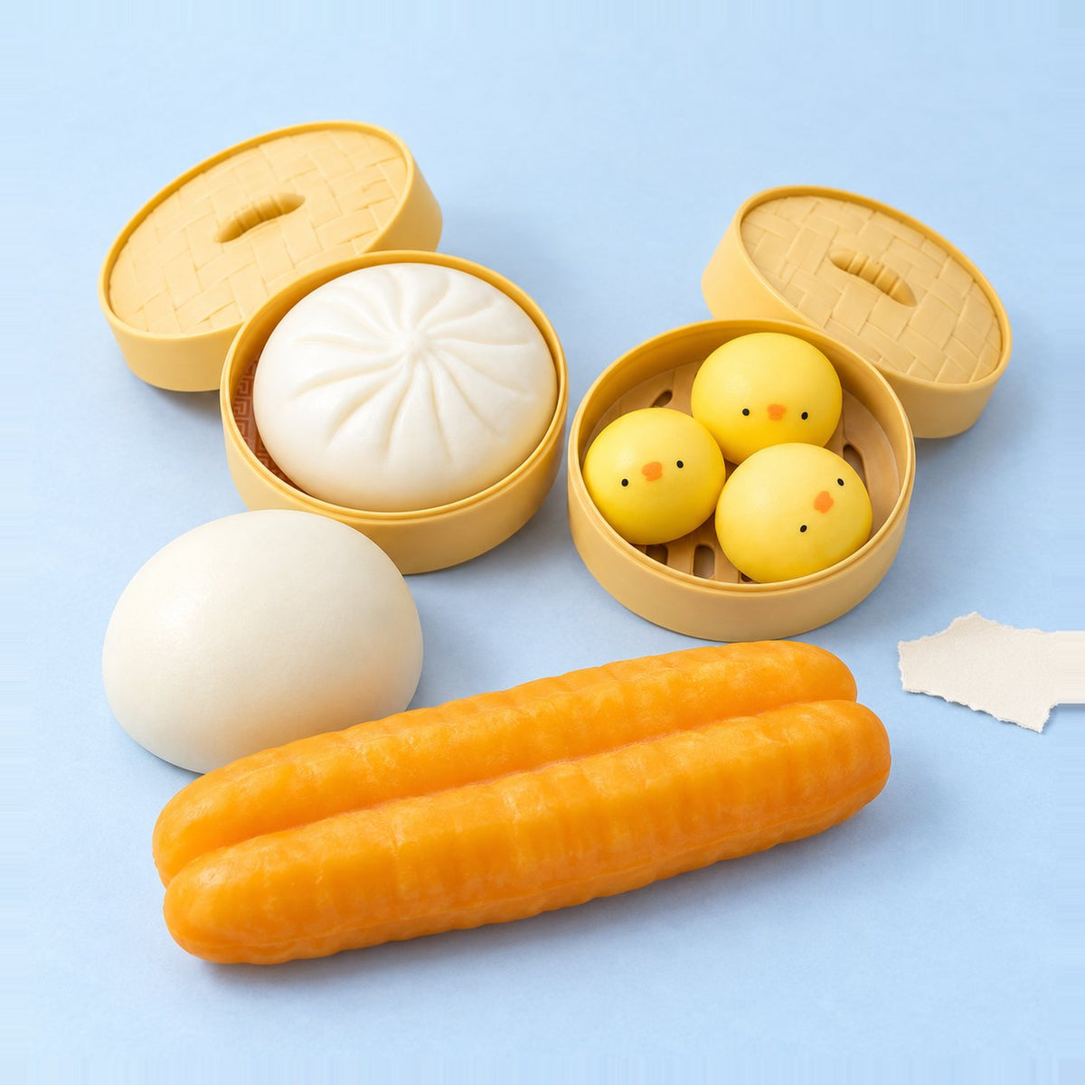 Dumpling-squishy-sæt med 4 stk., produktfoto på pastelfarvet papir