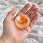 Egg yolk squishy coconut oil, held toward the camera, first-person view