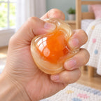 Egg Yolk Coconut Oil Squishy Ball, being squeezed by hand, soft and squishy