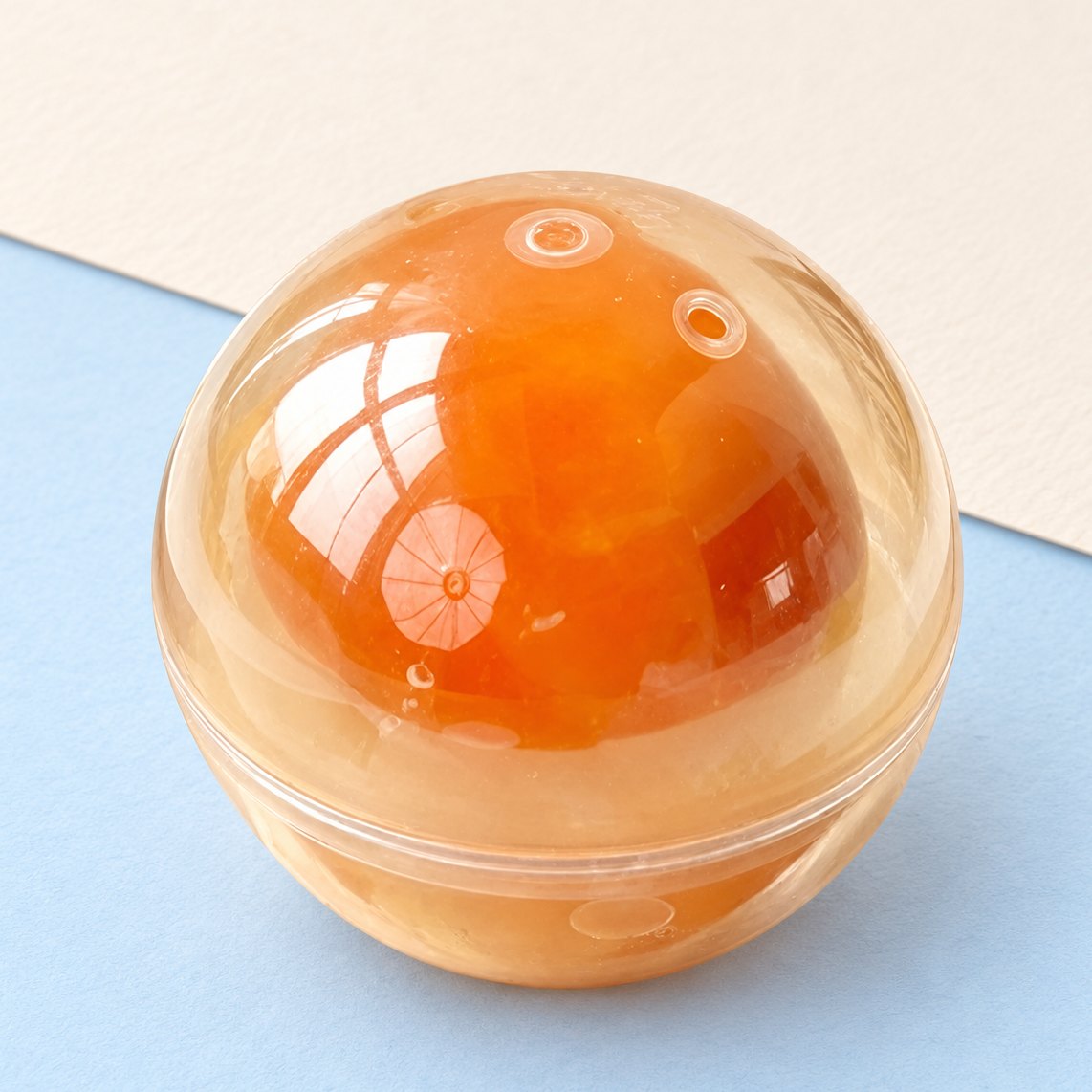 Eigeel squishy, een bal van 7 cm, op pastelkleurig papier