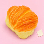 Flaky pastry squishy – Flaky Pastry Squishy, Oval Bun 8.7 cm, product photo on pastel paper