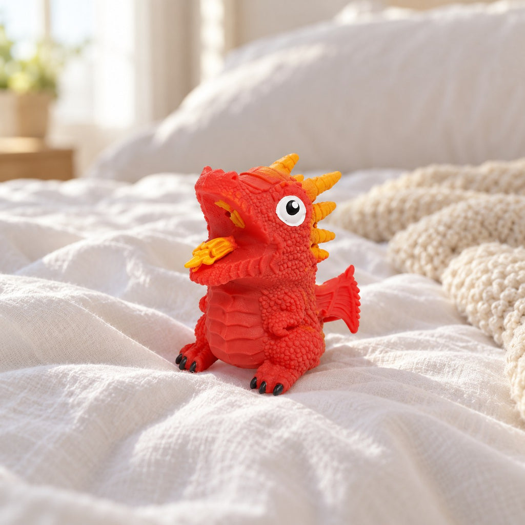 Flip dinosaur egg squishy (Red, dino style random), on a cozy bed with soft blankets