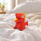 Flip dinosaur egg squishy (Red, dino style random), on a cozy bed with soft blankets