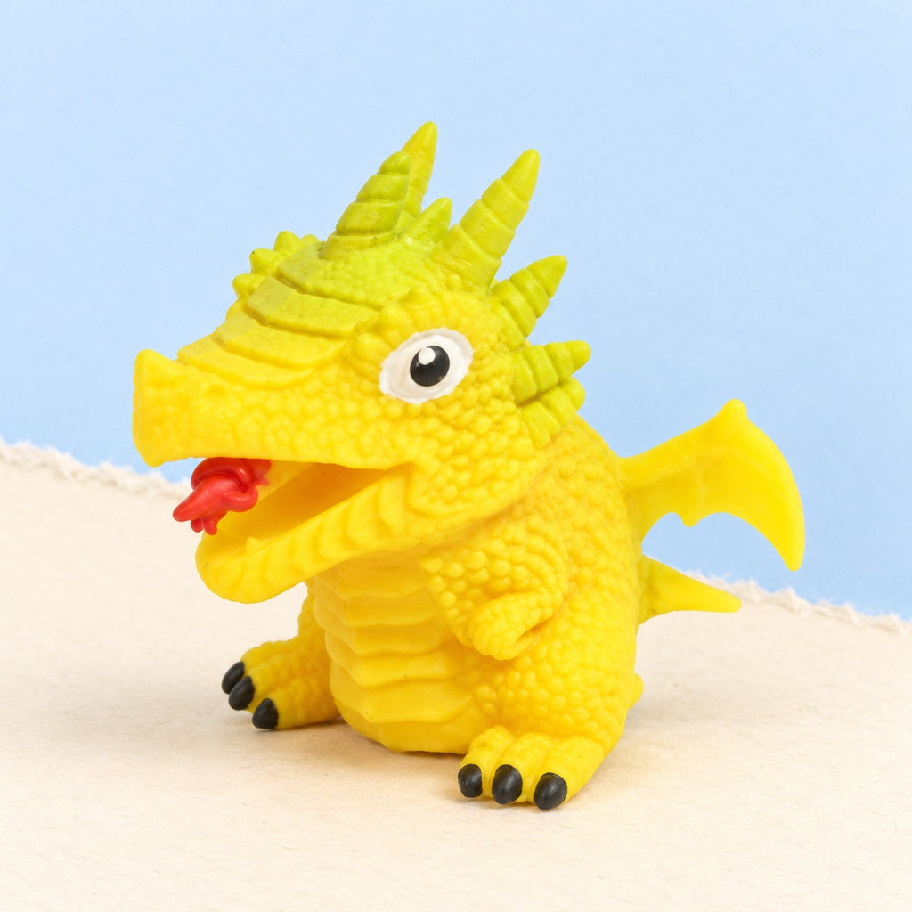 Flip dinosaur egg squishy turns inside out (Yellow, dino style random), product photo on pastel paper