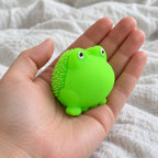Squishy žabka s měkkými bodlinkami, TPR, 5 cm, držený směrem k fotoaparátu z pohledu první osoby