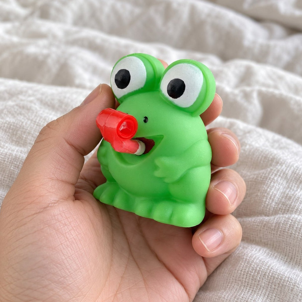 POV: Frosch oder Dino Squishy in der Frosch-Variante wird in die Kamera gehalten
