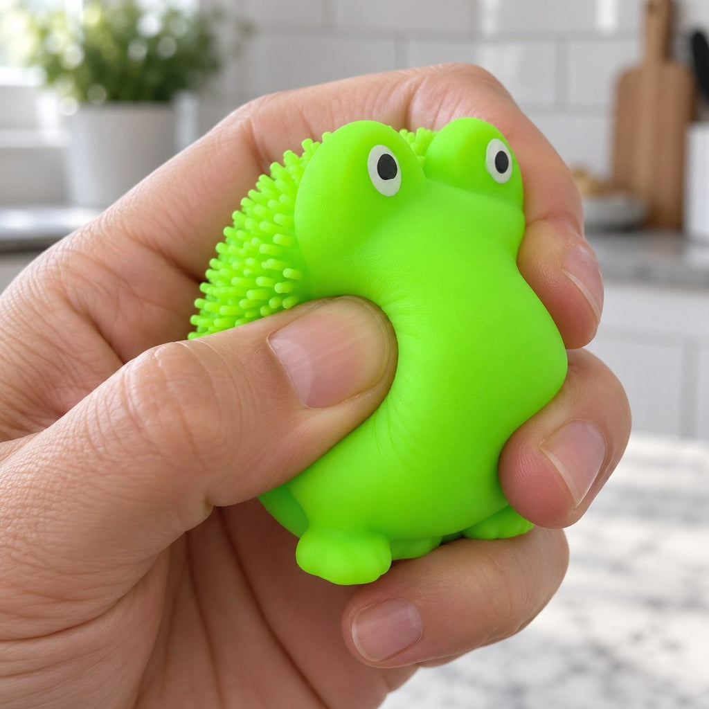 Frosch Squishy mit weichen Stacheln wird mit der Hand zusammengedrückt