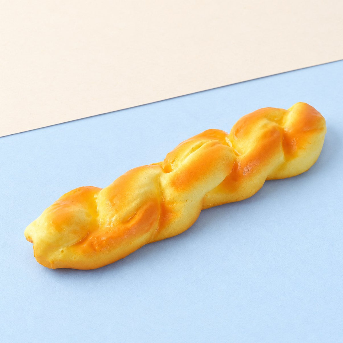Gedraaid brood squishy, broodstengel van 20 cm op pastelkleurig papier