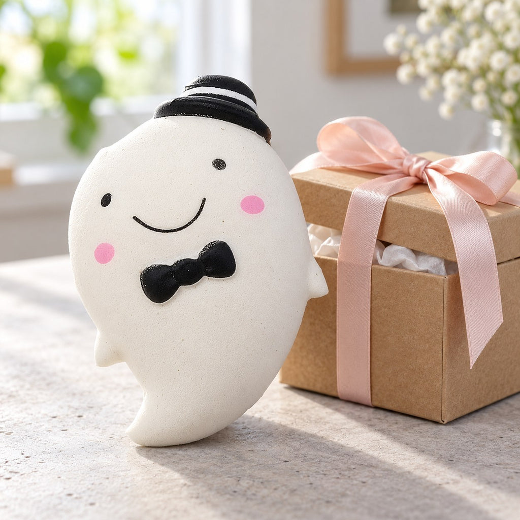 Slow Rising Ghost Squishy, 14.5 cm (white), as a small gift next to a wrapped box