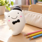 Slow Rising Ghost Squishy, 14.5 cm (white), on a school desk next to a pencil case