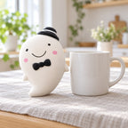 Slow Rising Ghost Squishy, 14.5 cm (white), next to a coffee mug for size comparison