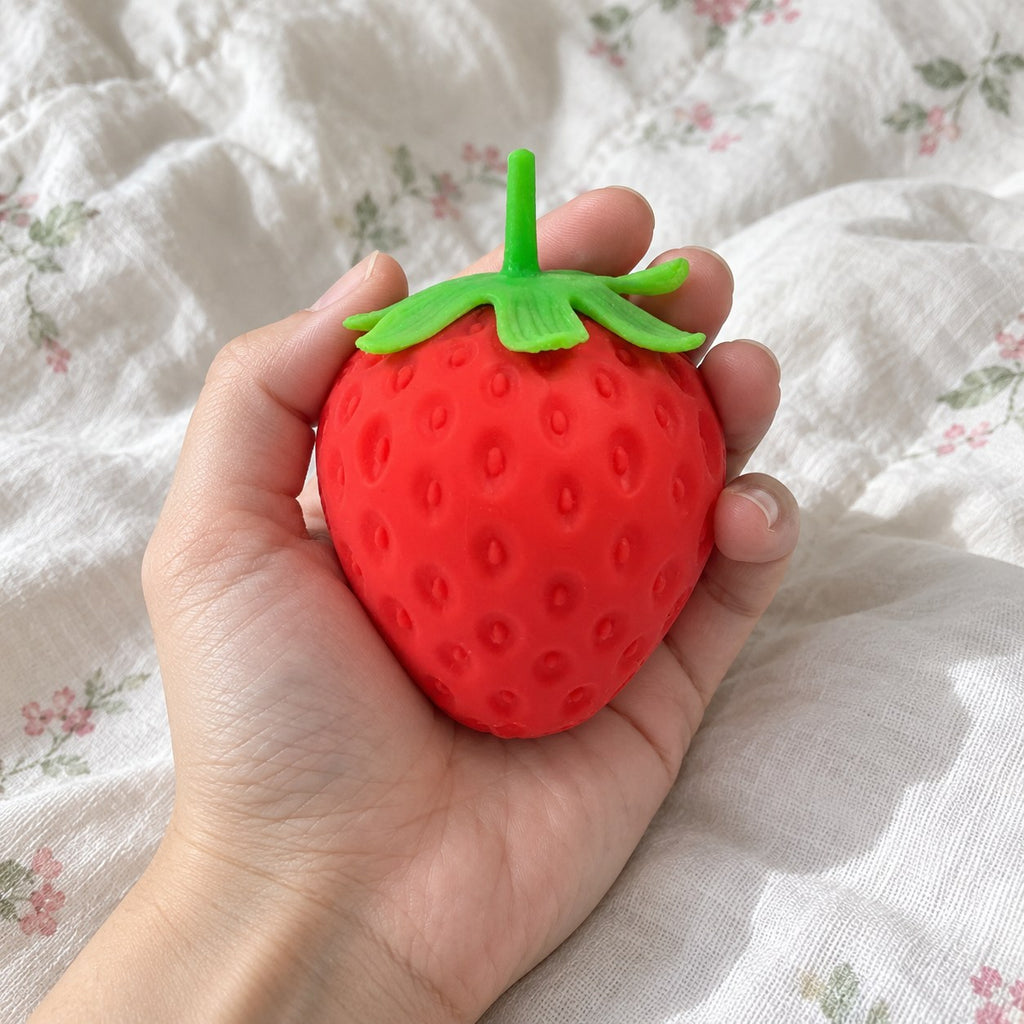 Giant strawberry squishy, held toward the camera, first-person view