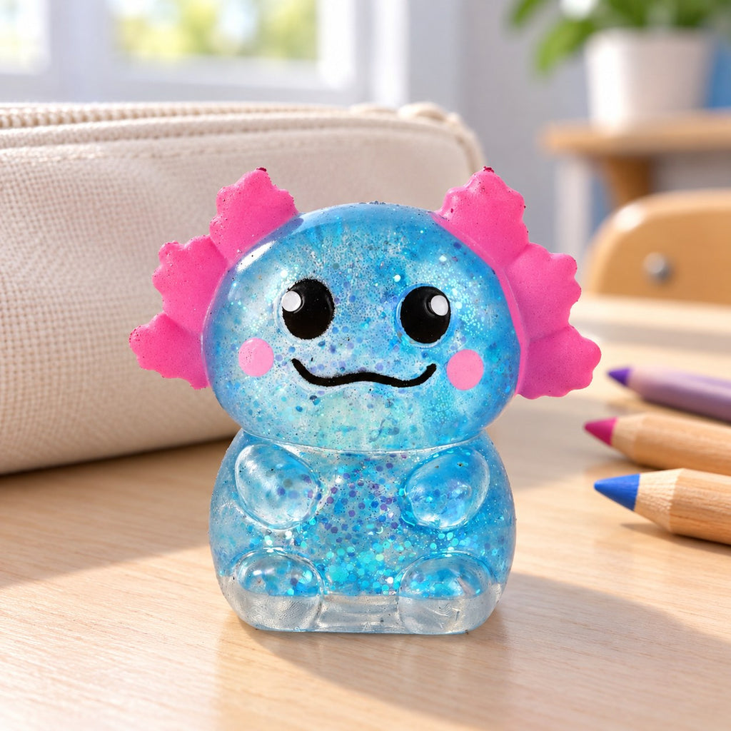 Glitter Axolotl Squishy, Slow Rising (blue), on a school desk next to a pencil case