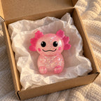 Axolotl squishy glitter (pink), unboxed from a parcel with tissue paper