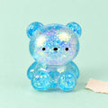Squishy ursinho com purpurinas gelatina maltose – Squishy ursinho com purpurinas, gelatina maltose, 3 tamanhos (Pequeno 4,7 cm, cor aleatória), fotografia do produto em papel pastel