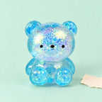 Squishy ursinho com purpurinas gelatina maltose – Squishy ursinho com purpurinas, gelatina maltose, 3 tamanhos (Pequeno 4,7 cm, cor aleatória), fotografia do produto em papel pastel