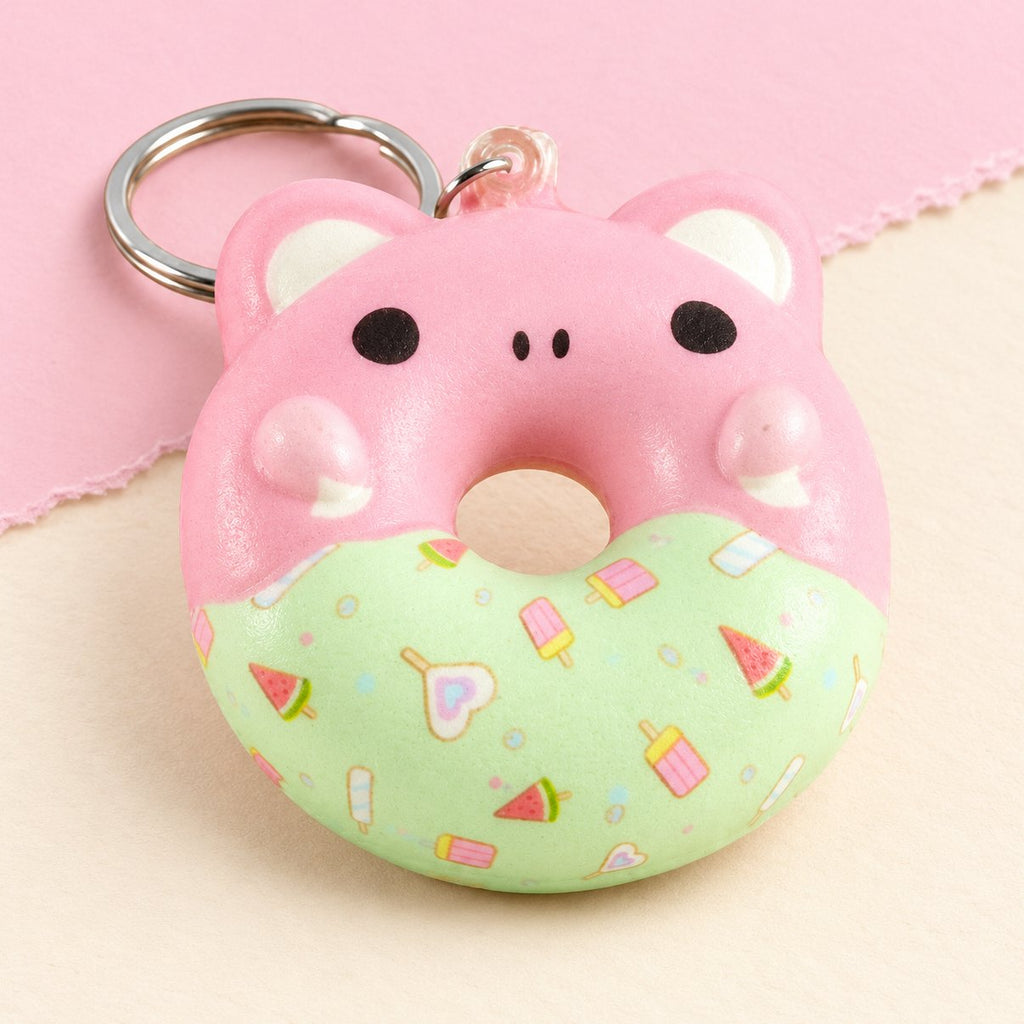 Gniotek brelok donut z buzią zwierzaka, slow rising, na pastelowym papierze