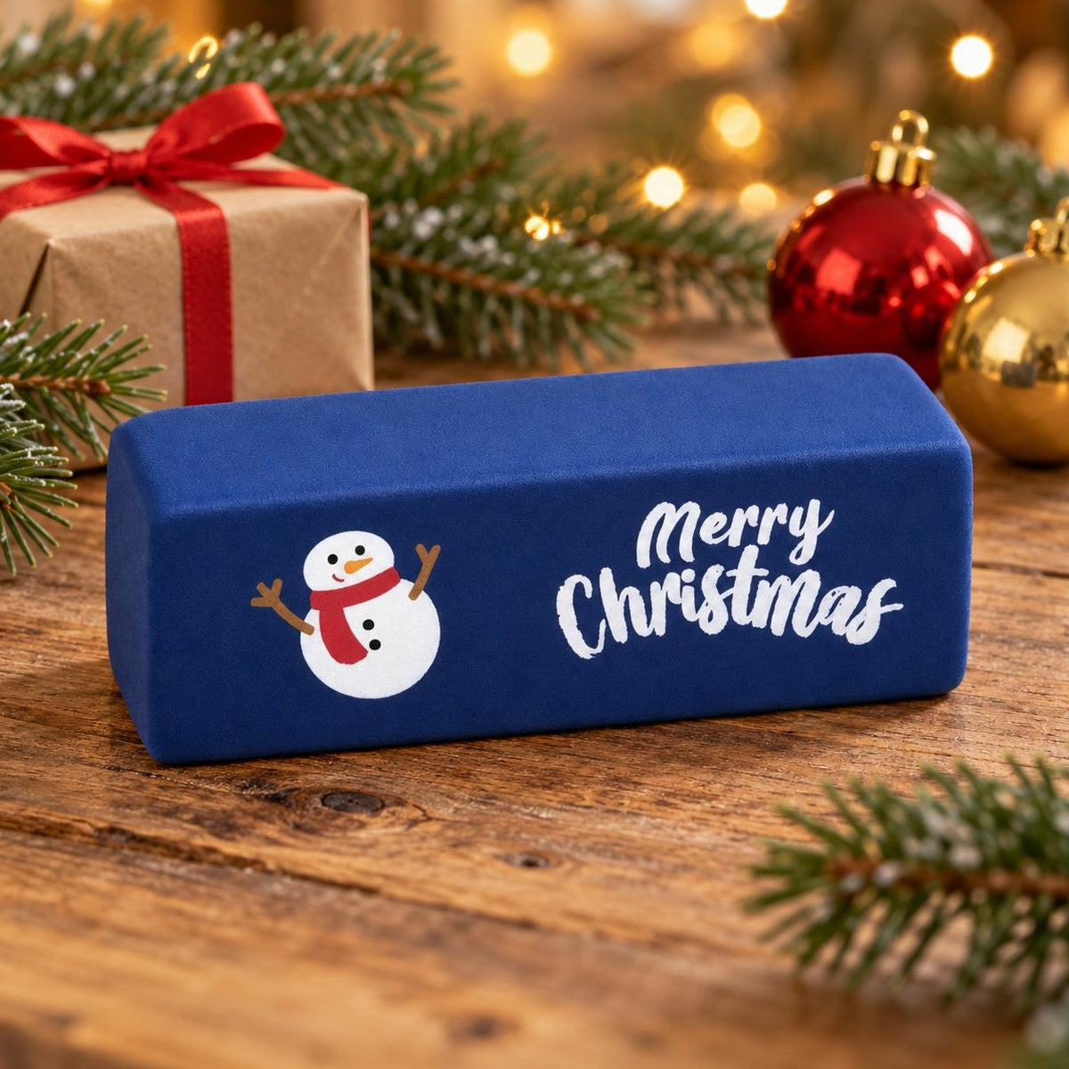 Granatowy gniotek masło merry christmas z bałwankiem wśród gałązek jodły i lampek