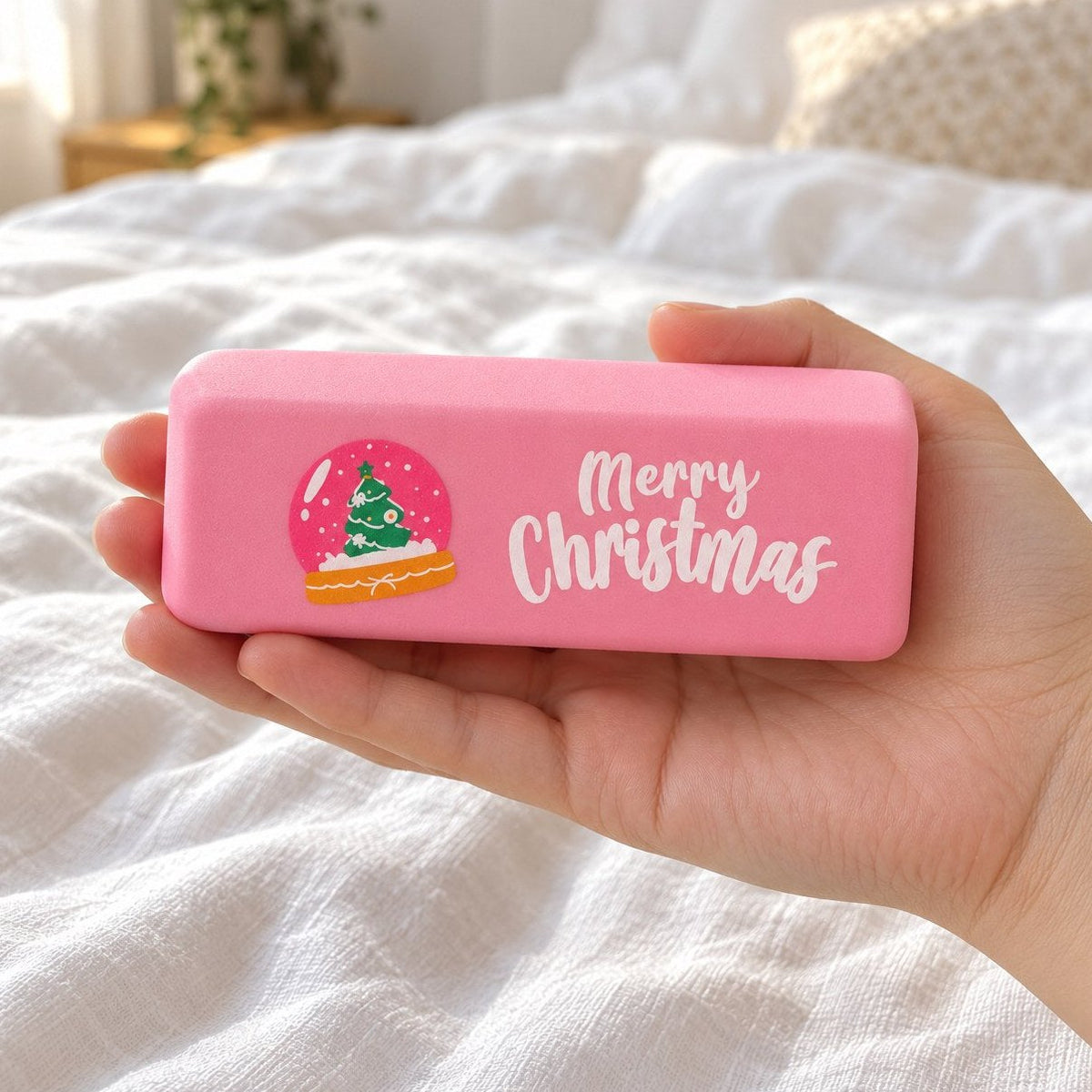 Różowy gniotek masło merry christmas z kulą śnieżną w dłoni